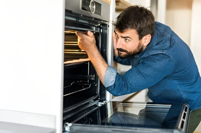 Technician repairing a wall oven in a National City home